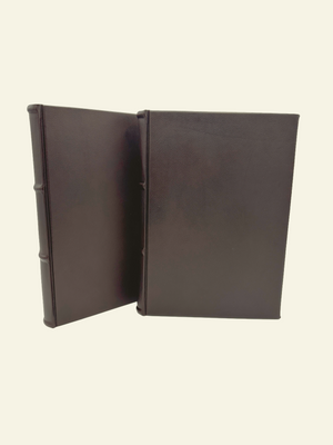 Two classic brown leather guestbooks and journals side by side