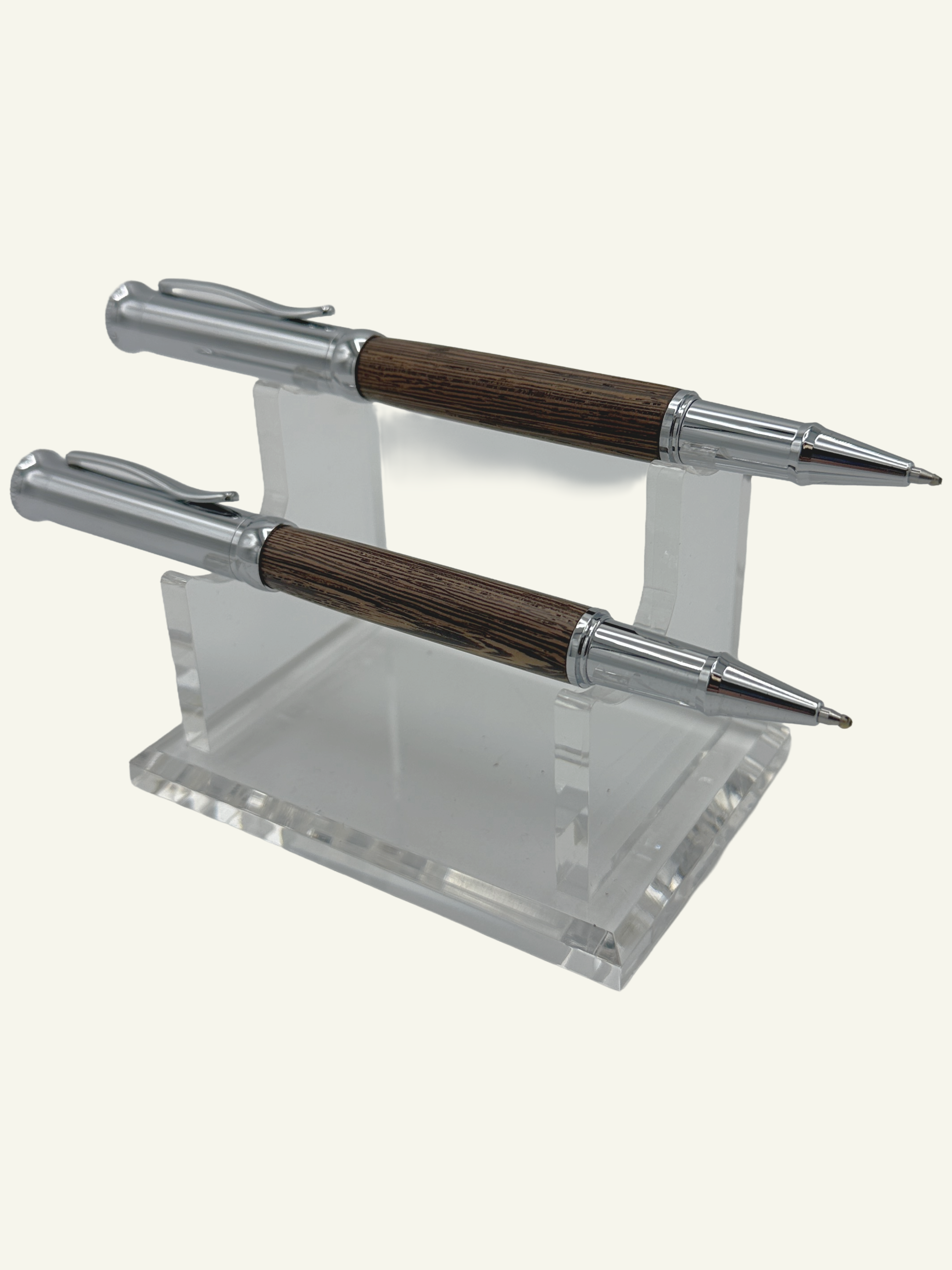Two luxury Italian wood rollerball pens with the cap off showcasing the polished chrome hardware and natural wood finish.