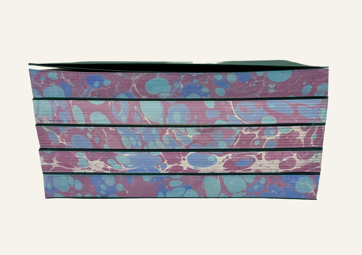 Marbleized stack of refillable journal inserts is blue and burgundy  
