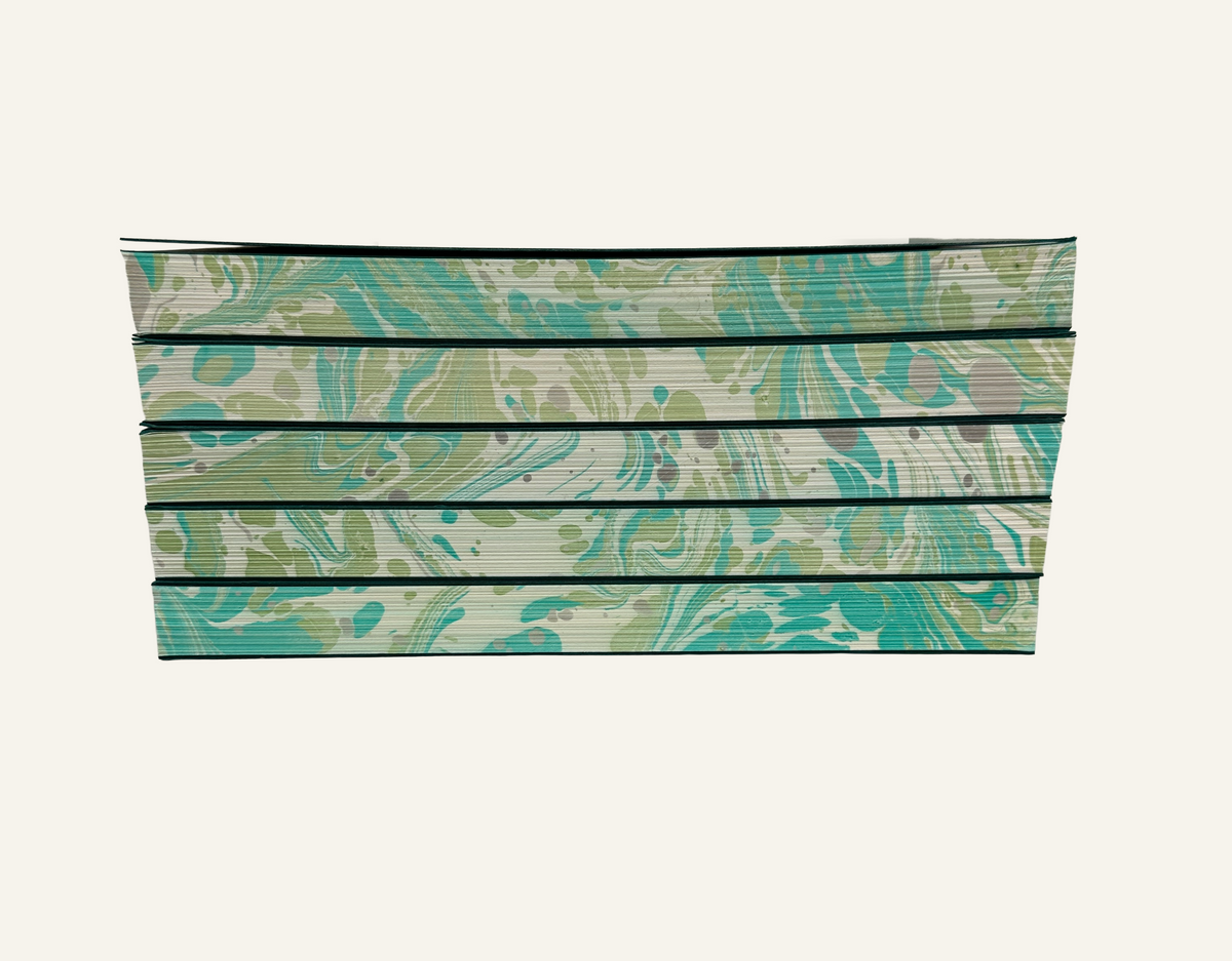 Stack of green and ivory marbled edge journal inserts for refillable journals 