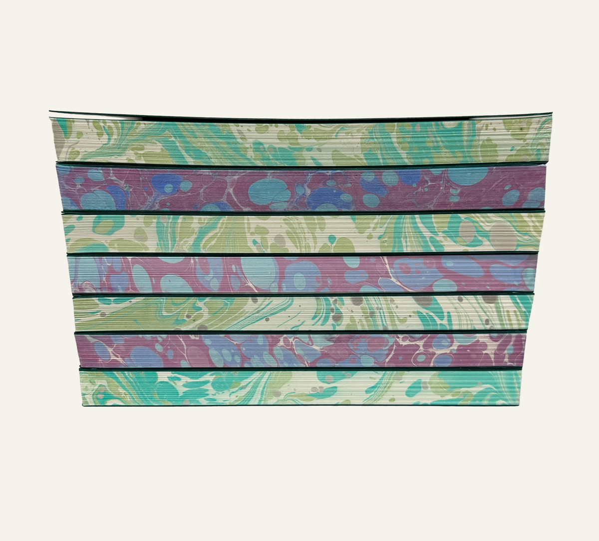 Marbleized edges of journal refill inserts tacked showing green and ivory and blue and burgundy 