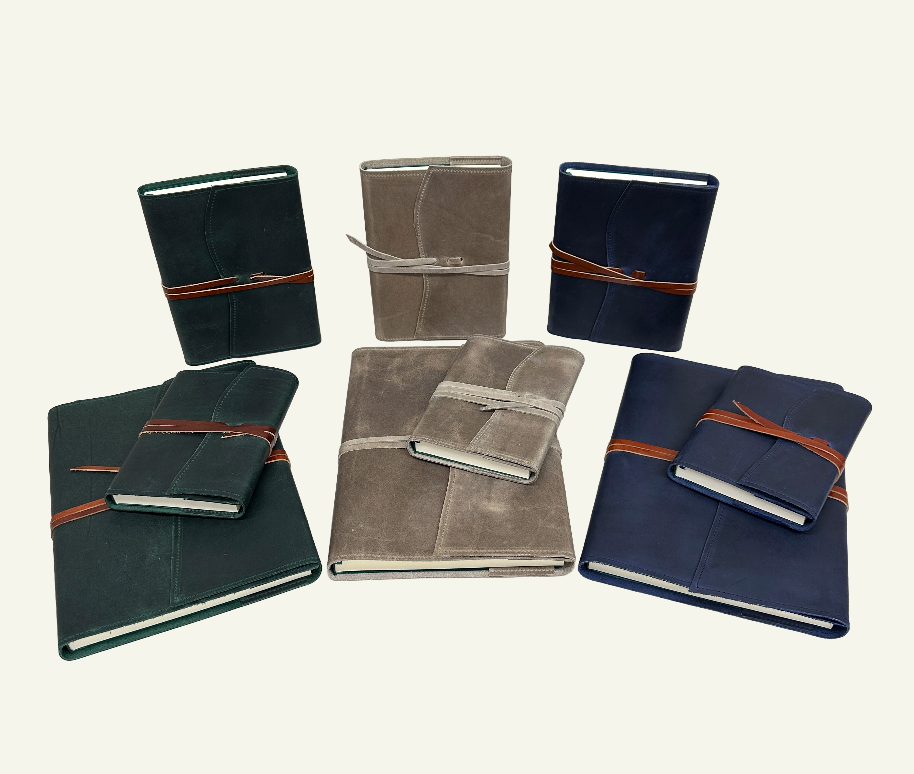 Collection of leather journals in dark green, taupe, and navy blue, shown in multiple sizes and orientations.