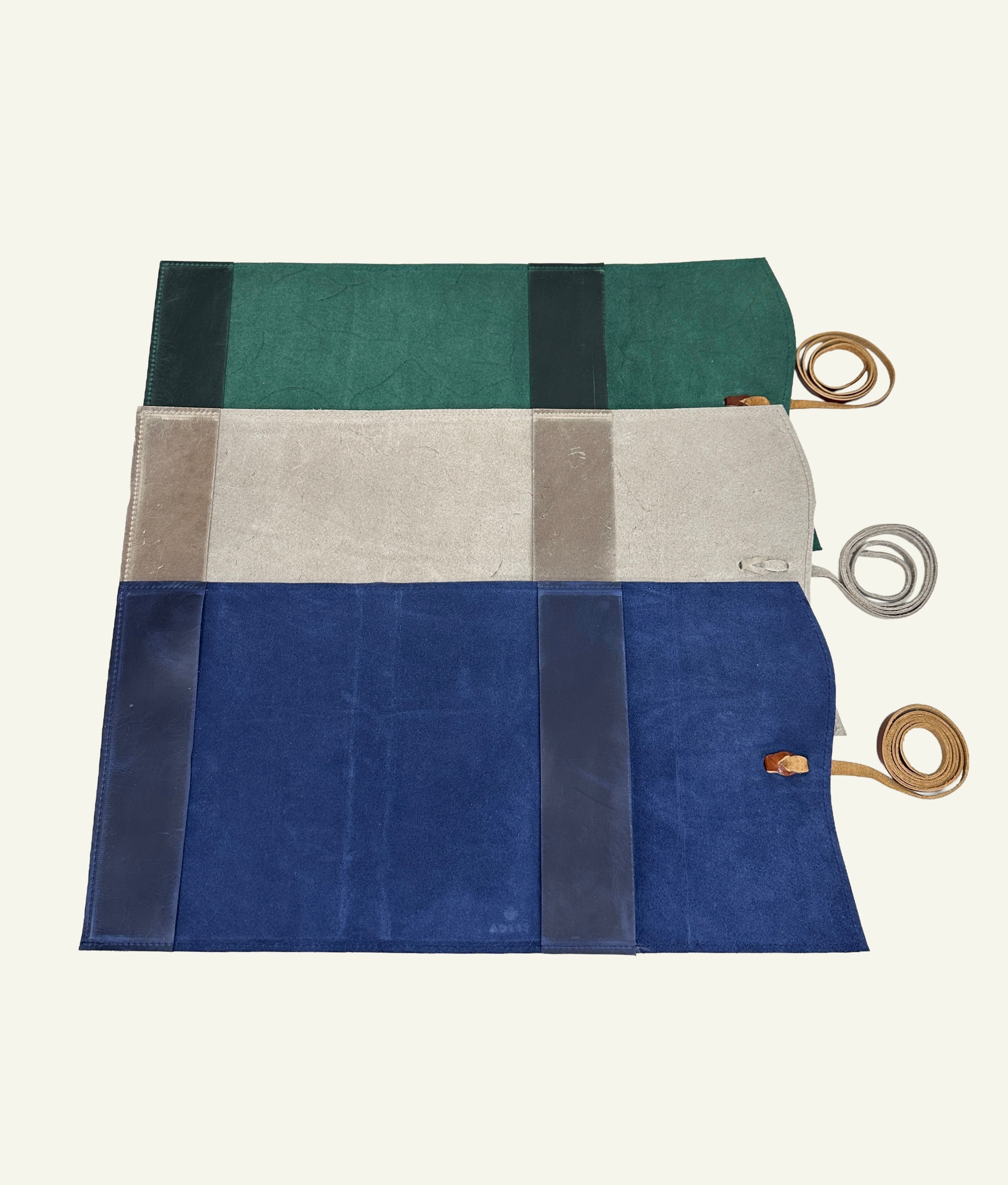 Interior view of forest green, stone taupe, and midnight blue refillable leather journal covers